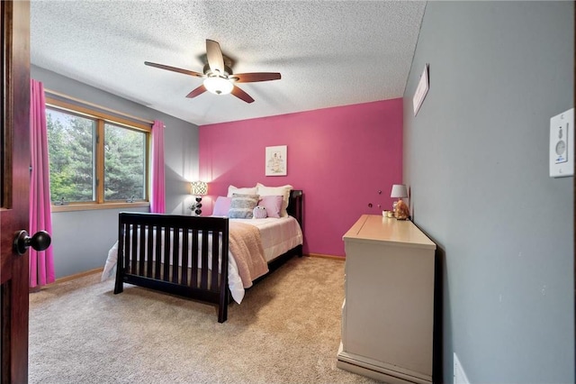 bedroom with light carpet, ceiling fan, a textured ceiling, and baseboards