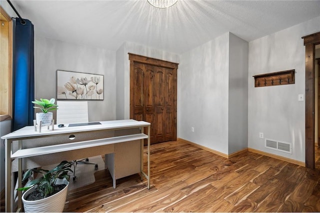 office featuring visible vents, wood finished floors, and baseboards