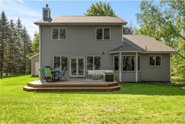 back of house with a chimney, a wooden deck, outdoor lounge area, and a yard