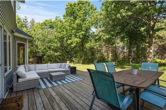 deck featuring outdoor dining space, an outdoor living space, and a lawn