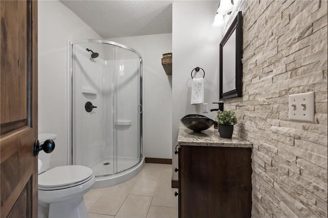 full bathroom featuring tile patterned flooring, a shower stall, a textured ceiling, and toilet