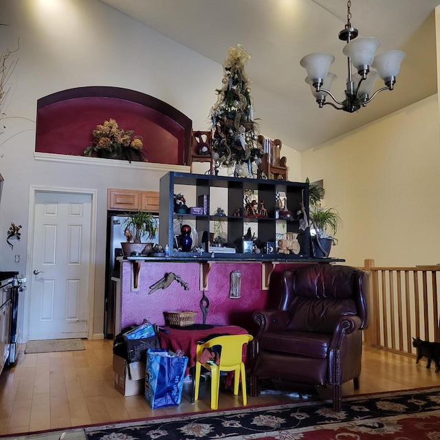 living room featuring wood finished floors, a chandelier, and vaulted ceiling