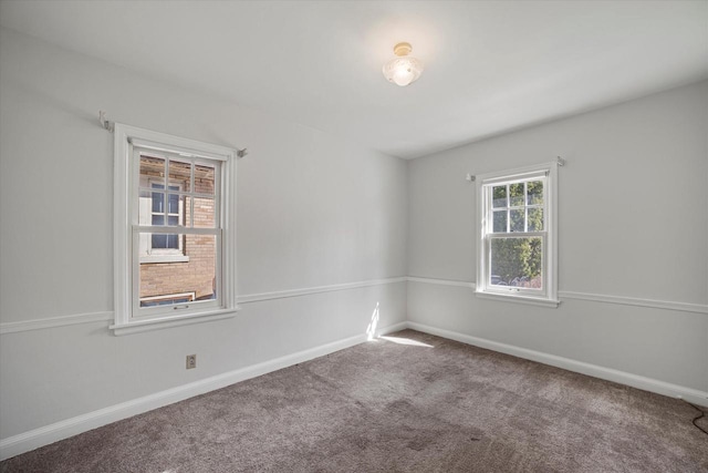 spare room with baseboards and carpet