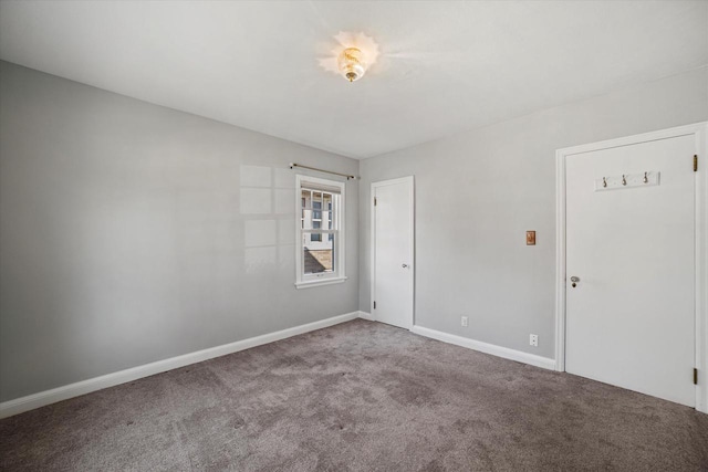 spare room featuring carpet flooring and baseboards