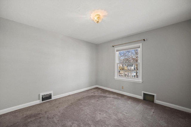 carpeted spare room featuring visible vents and baseboards