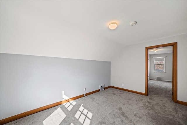 bonus room featuring lofted ceiling, carpet flooring, baseboards, and visible vents