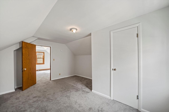 additional living space featuring baseboards, carpet floors, and vaulted ceiling