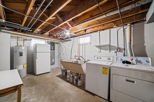 laundry area featuring water heater, laundry area, a sink, and separate washer and dryer