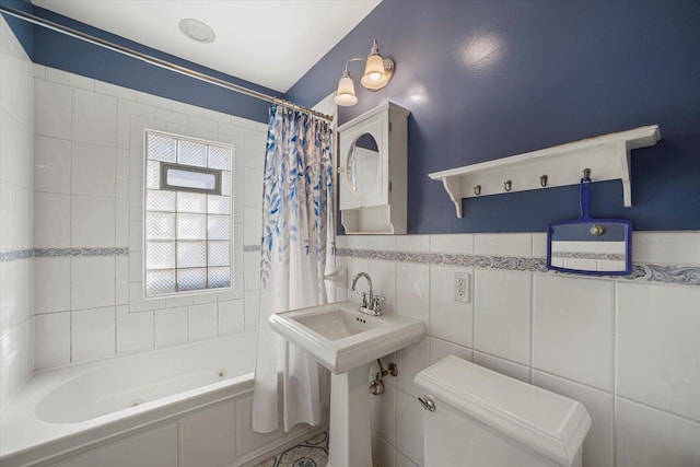 full bath featuring toilet, tile walls, and shower / bath combo