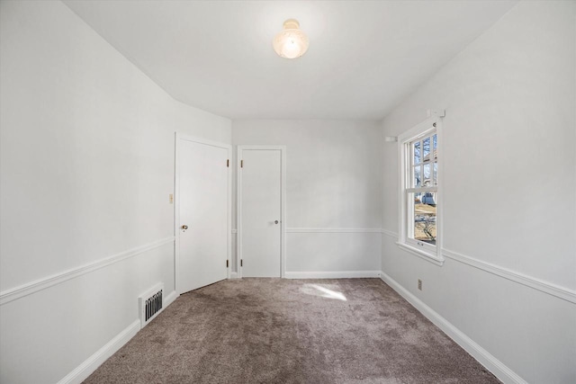 empty room with visible vents, baseboards, and carpet