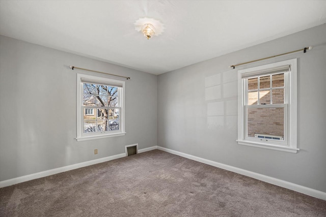 empty room with visible vents, carpet, and baseboards