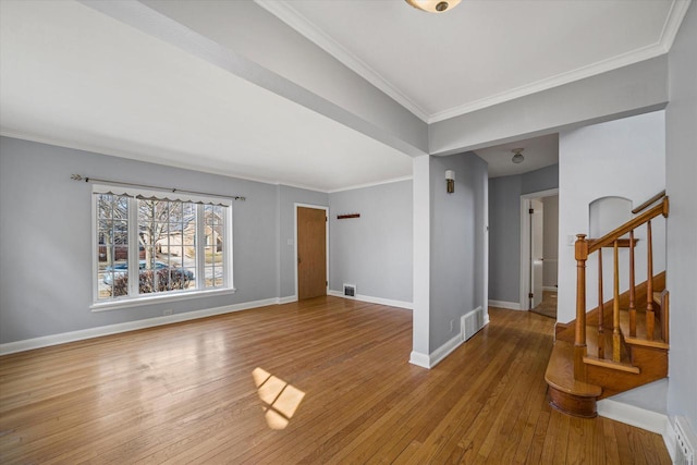 spare room featuring hardwood / wood-style flooring, stairway, baseboards, and visible vents