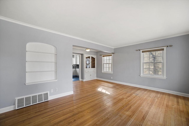 unfurnished room featuring visible vents, wood-type flooring, and baseboards