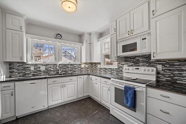 kitchen with decorative backsplash, white appliances, and a sink