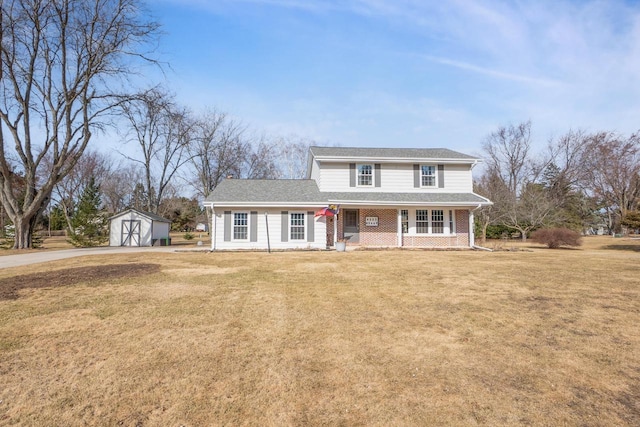 traditional-style house with brick siding, covered porch, a storage shed, and a front lawn