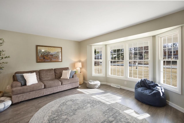 living area featuring visible vents, baseboards, and wood finished floors