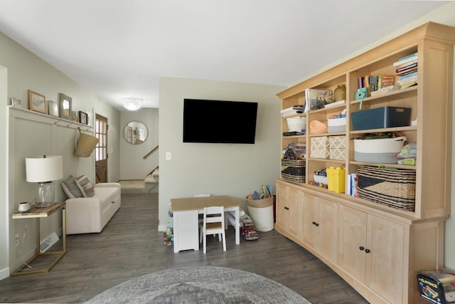 living area with stairway and dark wood-style flooring