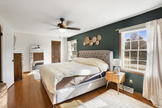 bedroom with baseboards, ceiling fan, and wood finished floors