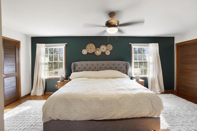 bedroom with a ceiling fan, baseboards, and wood finished floors