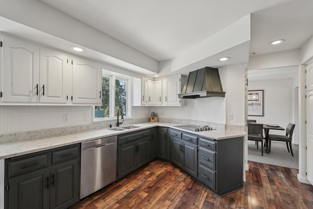 kitchen featuring white cabinetry, gray cabinetry, a sink, dishwasher, and wall chimney range hood