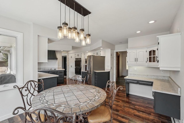 dining area with dark wood-style floors, recessed lighting, and an inviting chandelier