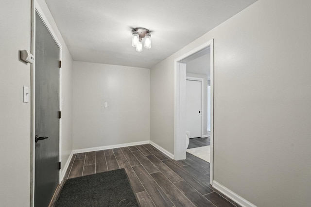 hallway with baseboards and wood finish floors