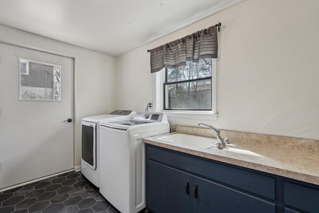 washroom with a sink, dark tile patterned floors, and washer and clothes dryer