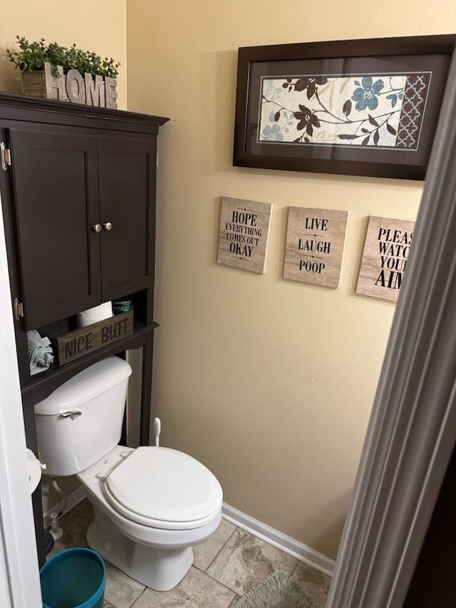 bathroom with baseboards and toilet