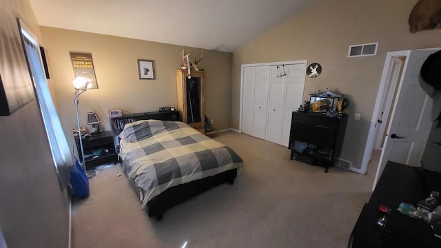 bedroom featuring visible vents, light colored carpet, a closet, and vaulted ceiling