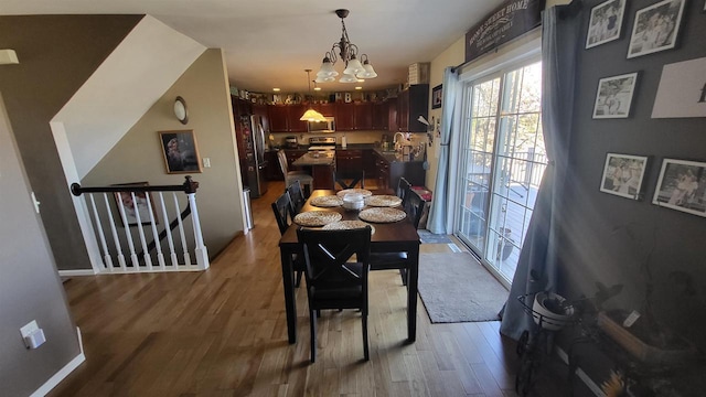 dining space with an inviting chandelier and wood finished floors