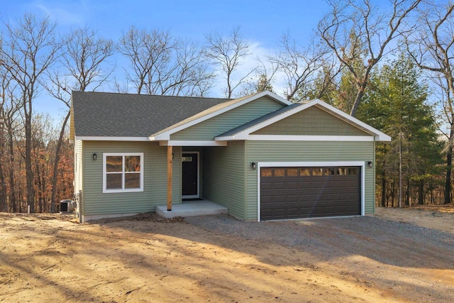 view of front of house featuring a garage, central AC, driveway, and a shingled roof