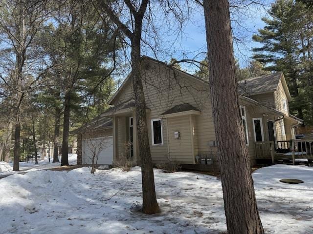 view of snow covered exterior with a garage