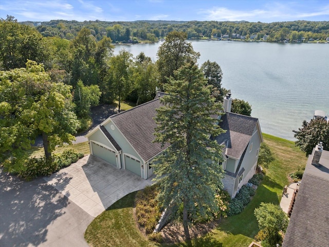 birds eye view of property featuring a forest view and a water view