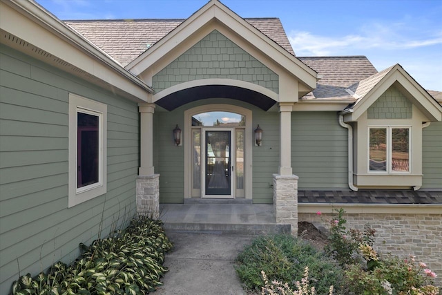 doorway to property with roof with shingles