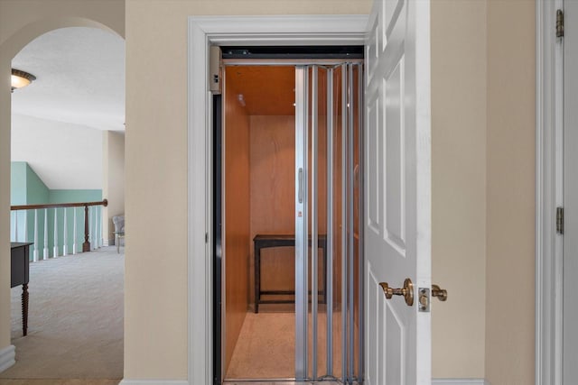 corridor with arched walkways and carpet flooring