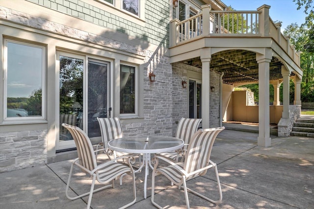 view of patio with outdoor dining area and a balcony