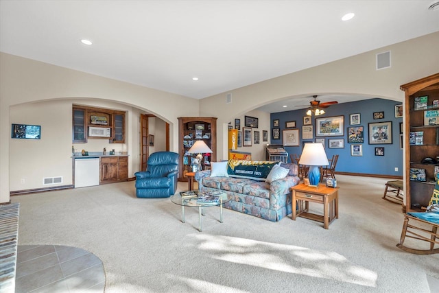 carpeted living room with recessed lighting, visible vents, and arched walkways