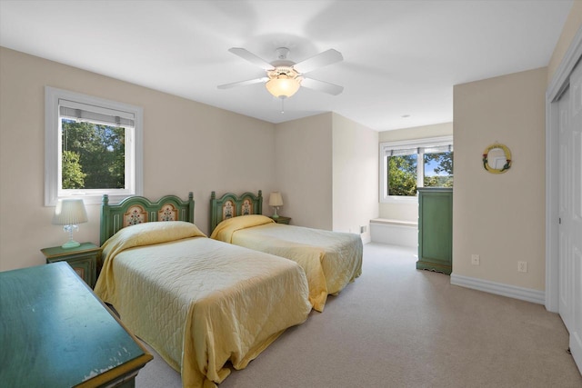 carpeted bedroom with a ceiling fan, baseboards, and a closet