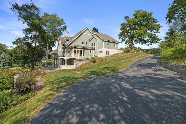 view of side of home featuring a lawn and a chimney