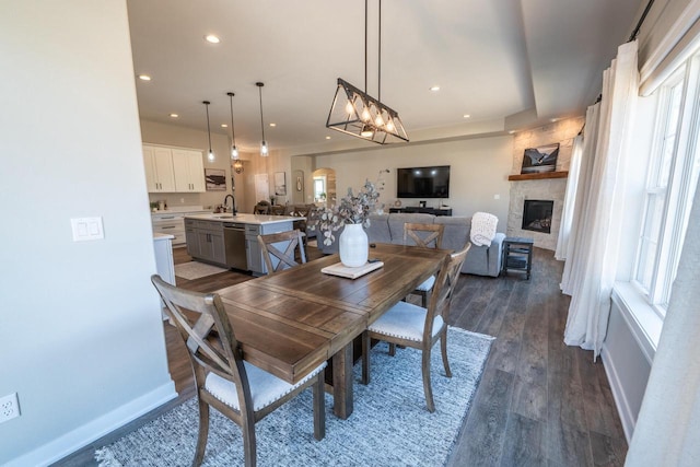 dining room featuring recessed lighting, arched walkways, dark wood-style floors, and a fireplace