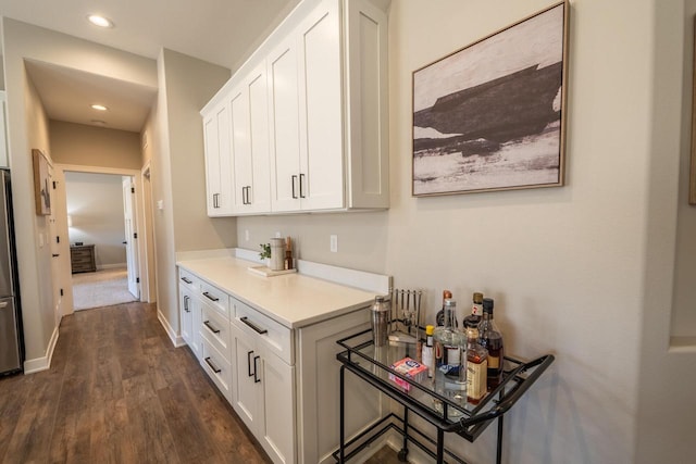 kitchen featuring white cabinetry, recessed lighting, light countertops, baseboards, and dark wood-style flooring