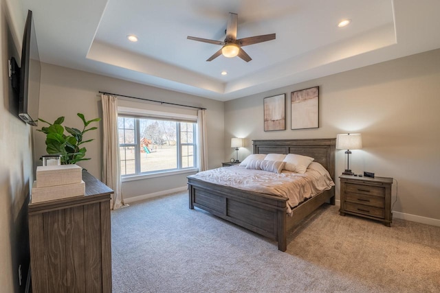 carpeted bedroom with recessed lighting, baseboards, and a raised ceiling