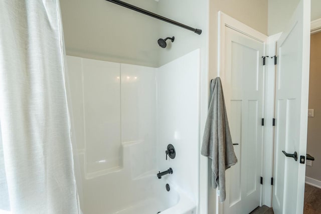 bathroom featuring baseboards and shower / bath combo with shower curtain