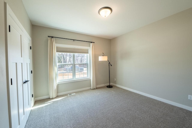 unfurnished bedroom featuring baseboards, light carpet, and visible vents