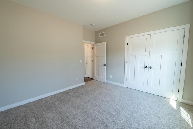 unfurnished bedroom with visible vents, baseboards, a closet, and carpet flooring