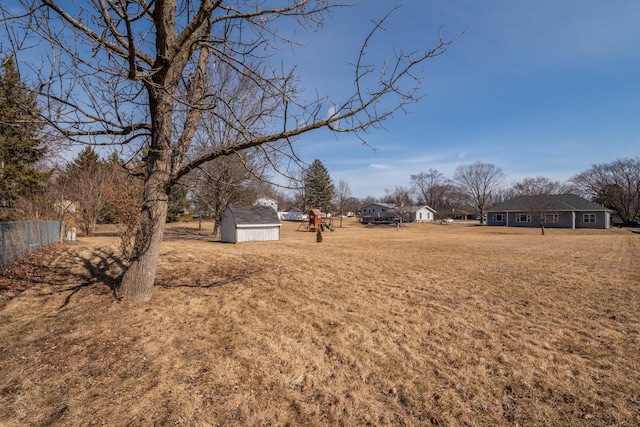 view of yard with an outbuilding, a shed, and fence