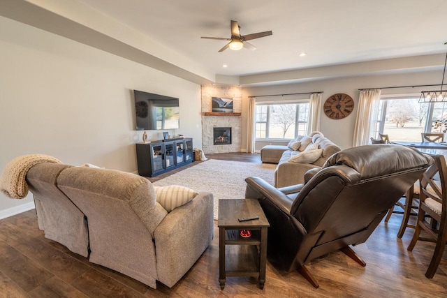 living room featuring plenty of natural light, recessed lighting, a large fireplace, and dark wood-style flooring