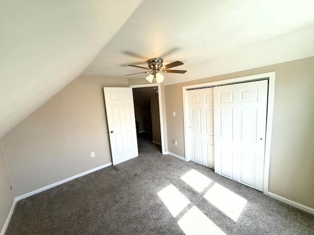 unfurnished bedroom featuring vaulted ceiling, a closet, baseboards, and carpet floors