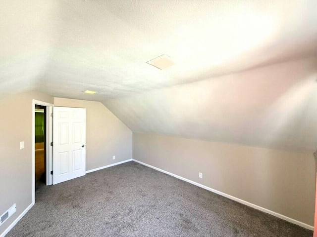 additional living space featuring visible vents, baseboards, carpet, and vaulted ceiling