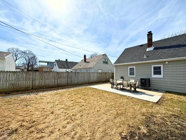 exterior space featuring fence, roof with shingles, central AC, a lawn, and a patio area